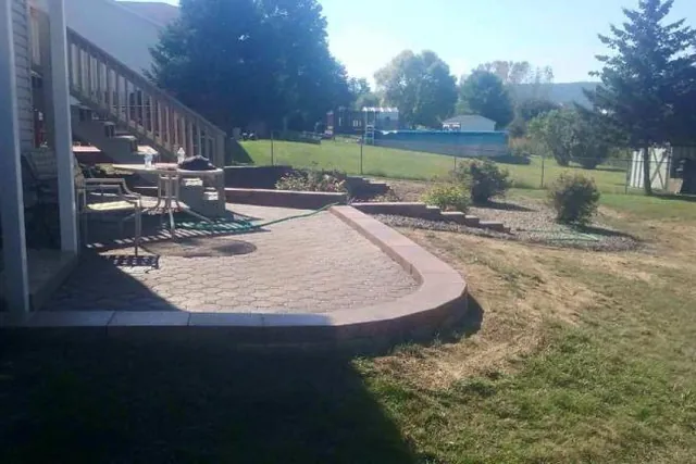 Backyard patio and lawn behind a house.