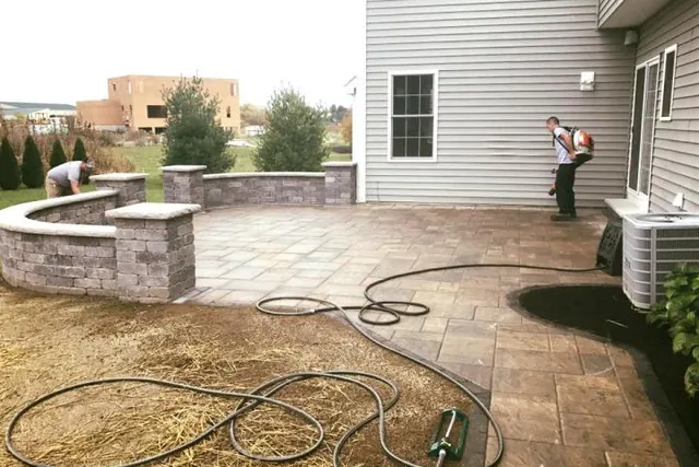 A stamped concrete patio mid-build with a low seat wall.
